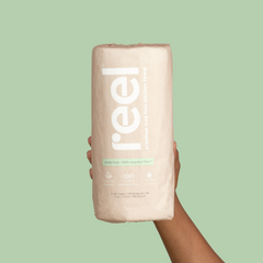 A hand holding recycled paper towels